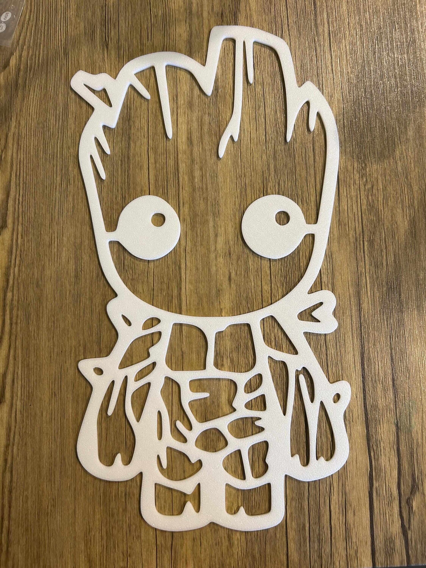 Baby Groot nursery decor cutout design on wooden background, perfect for adding charm to a nursery.