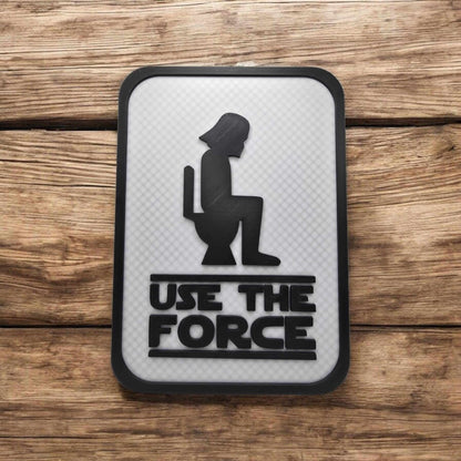 Funny bathroom decor featuring a sign with 'Use The Force' and a silhouette, perfect for any bathroom.