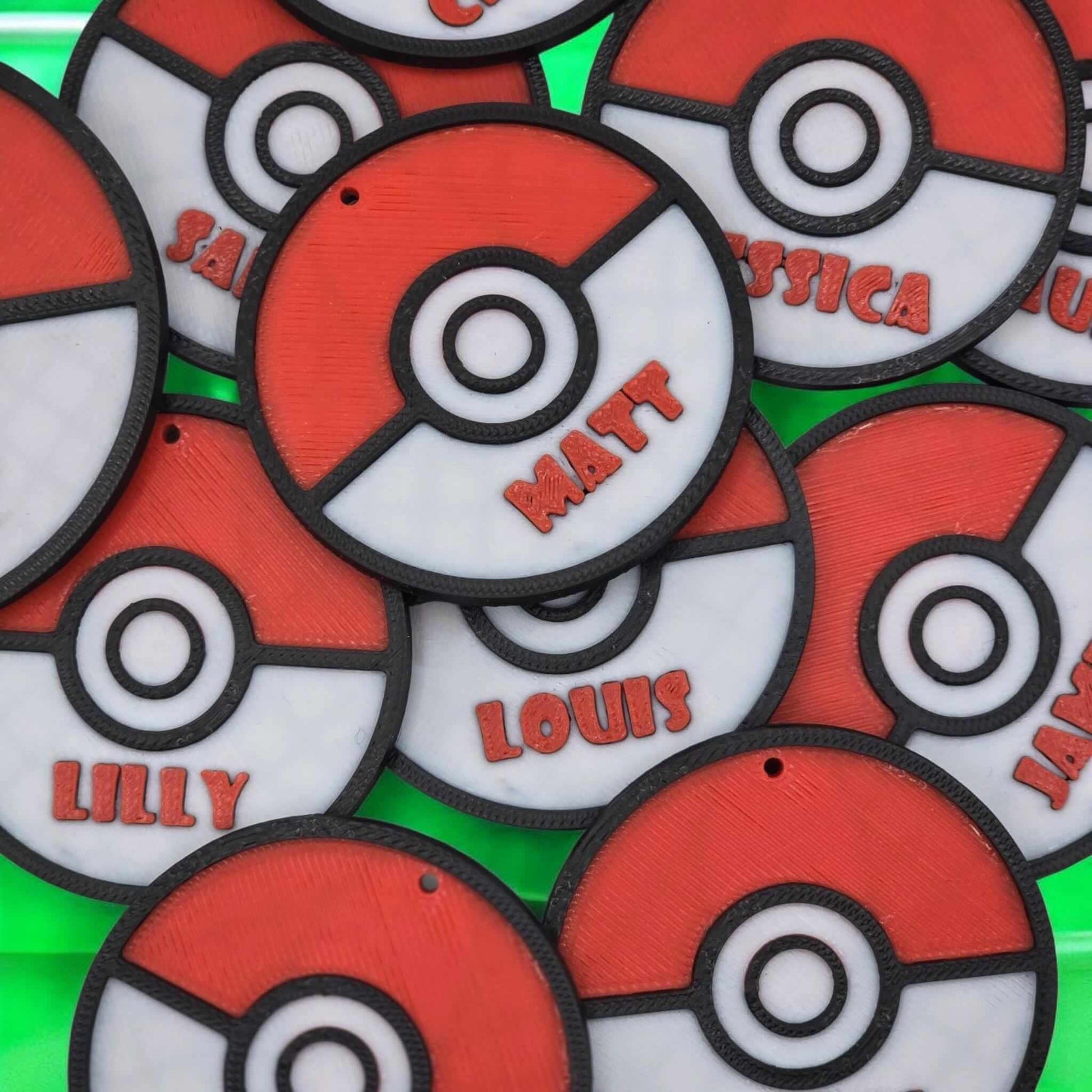 personalized Pokemon keychain with various names on Pokeball design, perfect for gifts and party favors