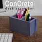 modern industrial desk organizer made to resemble a cinder block, storing pens and scissors.