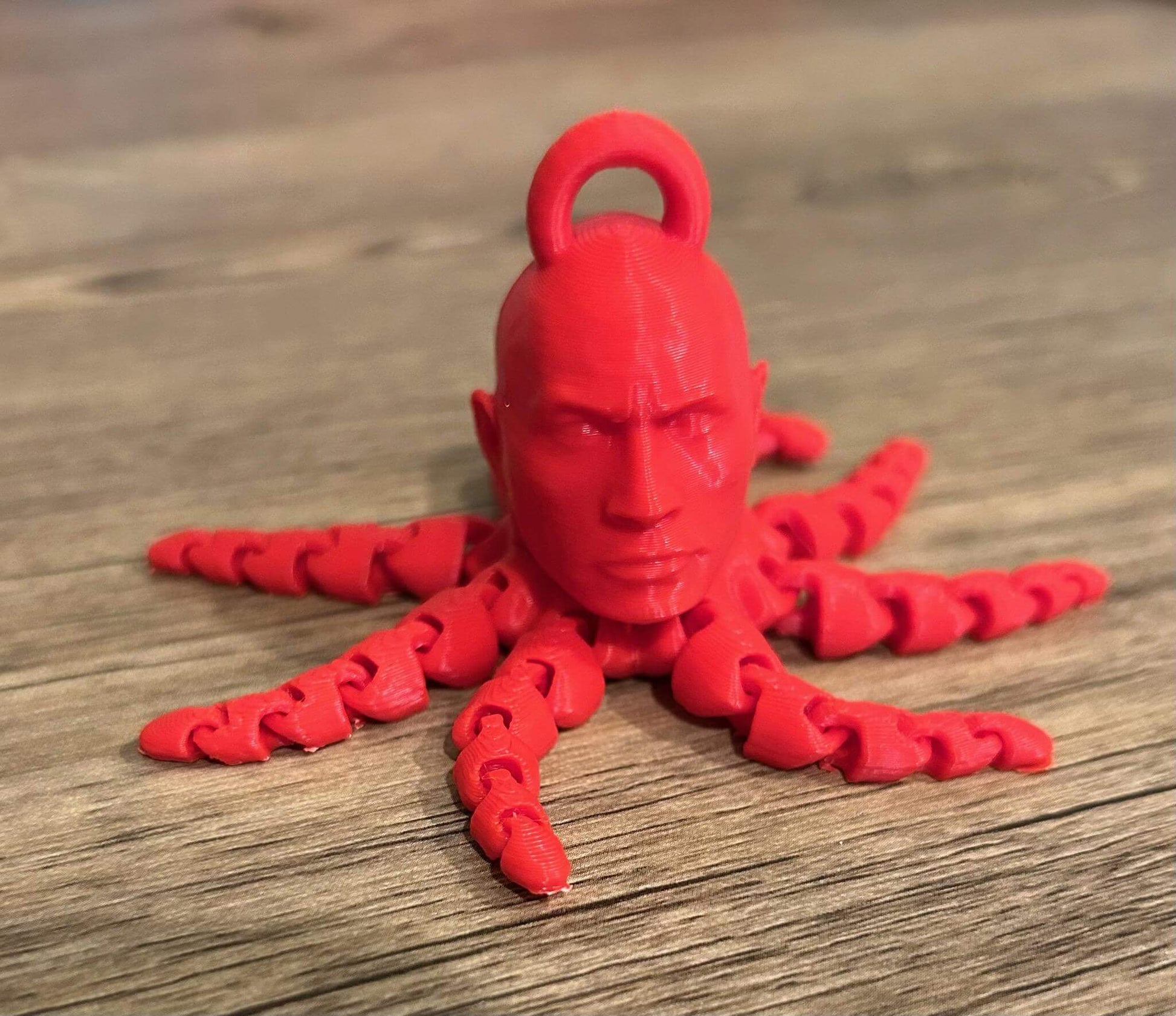Dwayne The Rocktopus keychain fidget in red, featuring a head and eight tentacles, ideal for fidgeting and conversation.