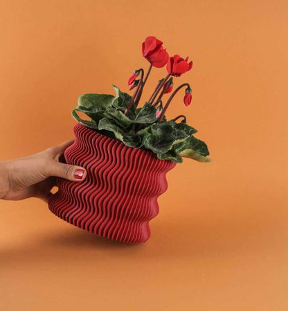 modern wavy planter with red flowers, ideal for home and office decor, featuring a sculptural wavy design.