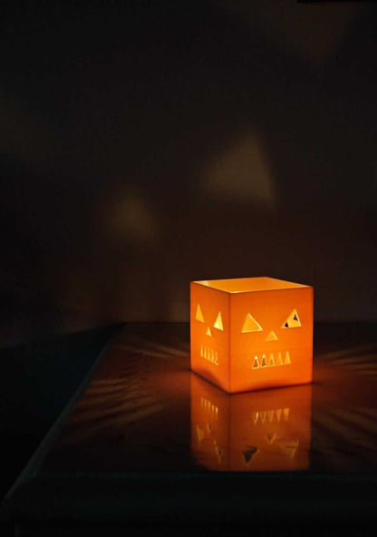 jack-o-lantern candle holder casting spooky shadows on the wall for Halloween decor.