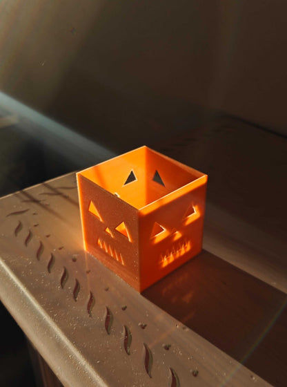jack-o-lantern candle holder casting spooky shadows on a wooden surface for Halloween decor.