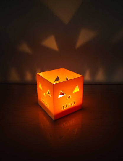 jack-o-lantern candle holder casting spooky shadows on a wall, perfect for Halloween decorations.